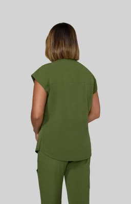 A green top with short sleeves, viewed from the back, worn by a model against a grey background.