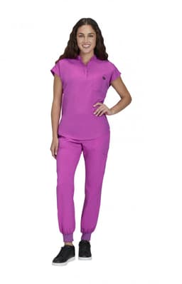 A woman stands in a vibrant purple outfit, comprising a short-sleeved top and fitted pants. The outfit has a small pocket and a logo.