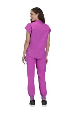 A woman wearing a pink top and pink pants, viewed from the back, standing against a white background.