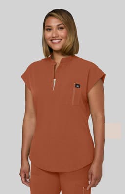 A top in a burnt orange colour with a rounded neckline and short sleeves, featuring a small pocket and a logo.