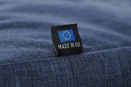 A blue fabric duffle bag featuring a tag that indicates it is made in the EU.