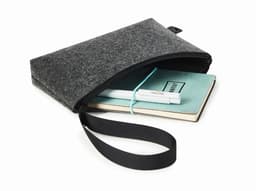A grey felt zipper bag contains a notebook and a pen, featuring a wrist strap for easy carrying.