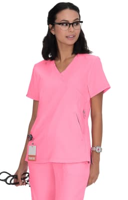 A pink medical top with a V-neck design and a zipper pocket, worn by a model holding glasses. It features a logo.