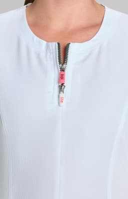 A close-up of a white top featuring a short zippered neckline and a subtle texture, showcasing a stylish design.