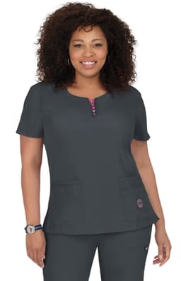 A woman models a dark grey medical scrubs top with a zip neckline and two pockets. It features a logo on the side.