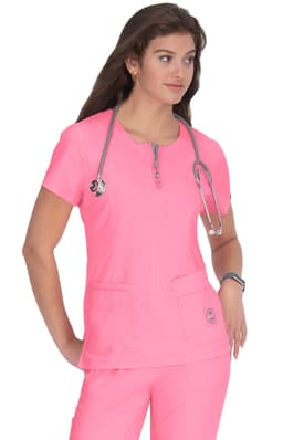 A medical scrubs top in vibrant pink, featuring a zip neckline and two front pockets, worn by a model with a stethoscope.