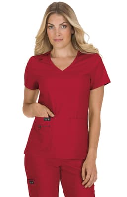 A woman wearing a red scrub top with a v-neck and two pockets, featuring a logo on one pocket.