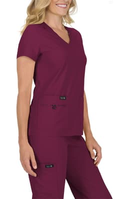 A scrubs top in a deep burgundy colour, featuring a v-neck and short sleeves, worn by a model.