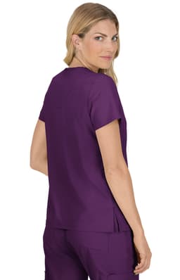 A woman in a purple top with a simple design, facing slightly back, features a logo on the fabric.
