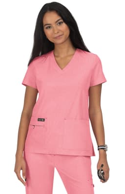 A pink scrub top with a V-neckline and two pockets, worn by a model with long dark hair.
