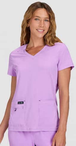 A medical top in light purple, featuring short sleeves and two front pockets, worn by a model.