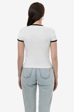 A white T-shirt with black trim on the sleeves, viewed from the back, paired with light blue jeans.
