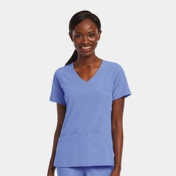 A womens mock wrap top in light blue with two front pockets and a V-neck design, featuring a branding logo.