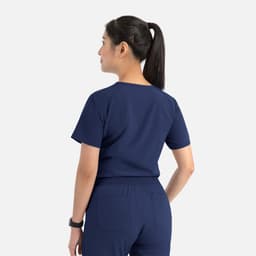 A women's navy blue tuckable V-neck top with short sleeves and a logo on the back.