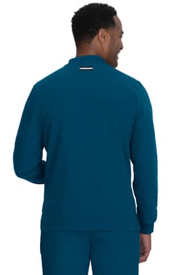 A man in a teal jacket is seen from the back, featuring a logo and a collar.