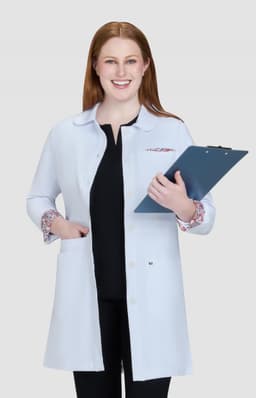 A lab coat in light blue with patterned cuffs, held by a smiling woman, with a clipboard in her hands.