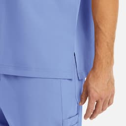 A light blue men's tuckable V-neck top, featuring a side slit and a close-up of the sleeve and hand.