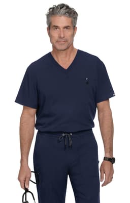 A navy blue scrub top featuring a V-neck design and a chest pocket, modelled by a man holding eyewear.