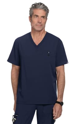 A navy v-neck scrub top featuring a chest pocket and a subtle logo. The model stands confidently in the garment.