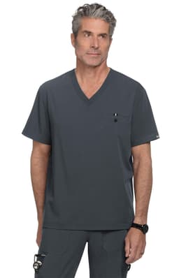 A grey scrubs top with a V-neck design and a pocket, worn by a model. The top features a logo.