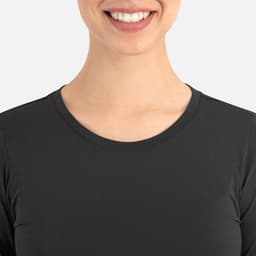 A close-up of a person's upper chest and neck wearing a black, round-neck underscrub tee.