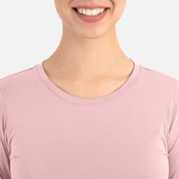 A close-up of a woman's neckline wearing a light pink underscrub tee. The tee features a round neckline.