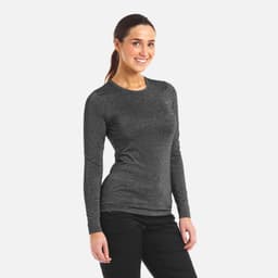A woman wears a long-sleeved, grey underscrub tee. The top has a fitted style and includes a logo.