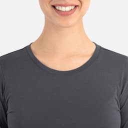 A close-up of a women's grey underscrub tee with a round neckline, featuring a smiling model.