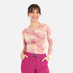 A long-sleeved women's underscrub tee in a pastel tie-dye pattern featuring shades of pink and yellow.