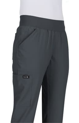 A pair of dark grey pants with a flexible waistband and pockets, featuring a logo on the side.