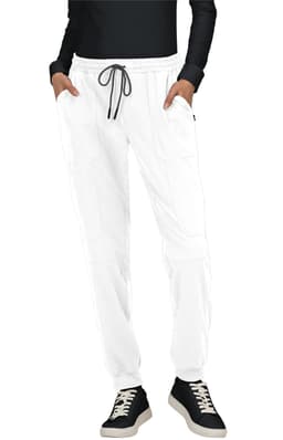 A pair of white jogger pants with pockets, featuring an elastic waistband and drawstring, styled with a black top and shoes.