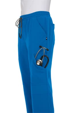 A pair of blue jogger pants featuring a pocket with a stethoscope. The pants have an elastic waistband and drawstring.