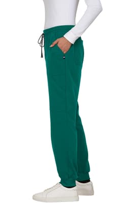 A green jogger pant with pockets and a drawstring waistband, styled with a fitted top and white sneakers.