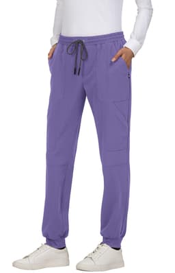 A pair of purple jogger pants with side pockets and drawstring waist, styled with a white long-sleeve top and white sneakers.