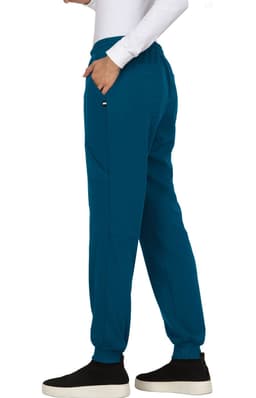 A side view of teal jogger pants with a relaxed fit and pockets, paired with black footwear.
