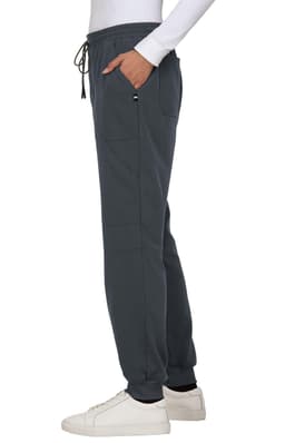 A pair of dark grey jogger pants with a drawstring waist and side pockets, styled with a white long-sleeve top and white shoes.