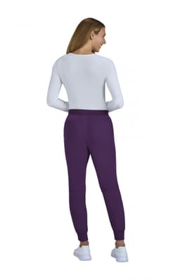 A pair of purple jogger pants worn by a model. The model is facing away, wearing a white top and white shoes.