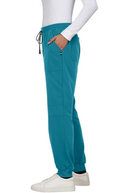 A pair of teal jogger pants with pockets and an elastic waistband, worn with white sneakers.
