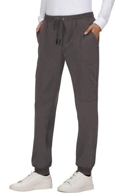 A pair of grey jogger pants with pockets and an elastic waistband, styled with a white top and sneakers.