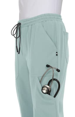 A pair of light mint jogger pants featuring side pockets, one holding a stethoscope, and a drawstring waist.