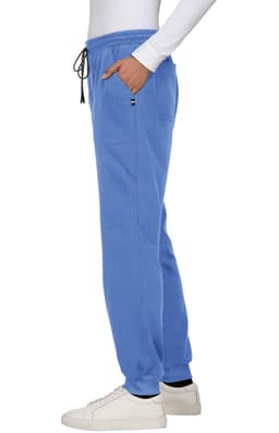 A pair of blue jogger pants with pockets and an elastic waistband, styled with a white long-sleeved top.