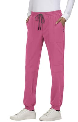 A pair of pink jogger pants with pockets and an elastic waistband, modelled by a person wearing a white top and shoes.