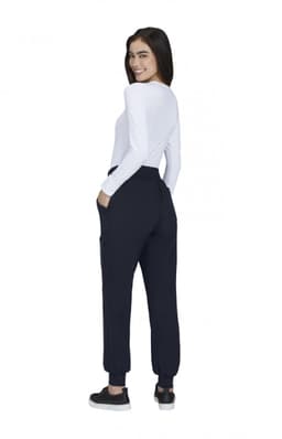 A woman wearing navy jogger pants with pockets, facing away, paired with a long-sleeve white top.