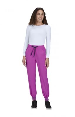 A woman in a white long-sleeve top wears vibrant pink joggers with a black drawstring and elastic cuffs.