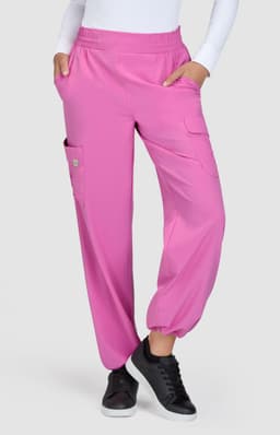 Bright pink pants with a relaxed fit, featuring side pockets and an elastic waistband. A logo is visible on the garment.