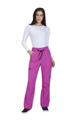 A woman wearing bright pink wide leg pants with pockets, paired with a white long-sleeve top.