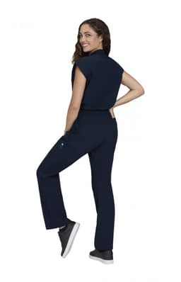 A navy blue Anja Jumpsuit worn by a model, featuring a fitted design and a pocket, displayed from the side.