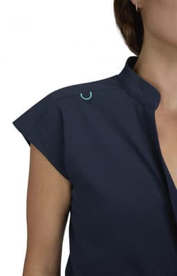 A navy blue jumpsuit featuring a collar and cap sleeves, with a decorative logo on the shoulder.