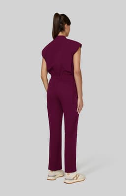 A maroon jumpsuit with short sleeves and a relaxed fit, featuring a cinched waist and straight leg design.
