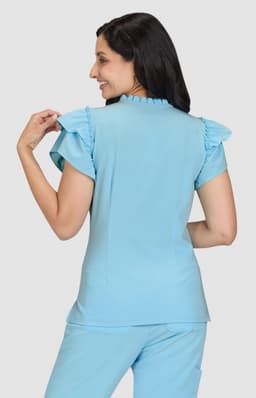 A top in light blue with ruffle details on the sleeves, worn by a model from the back.